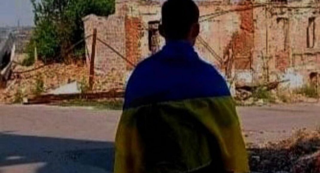 В Мариуполе юноша сфотографировался у разбомбленного дома с флагом Украины (фото)